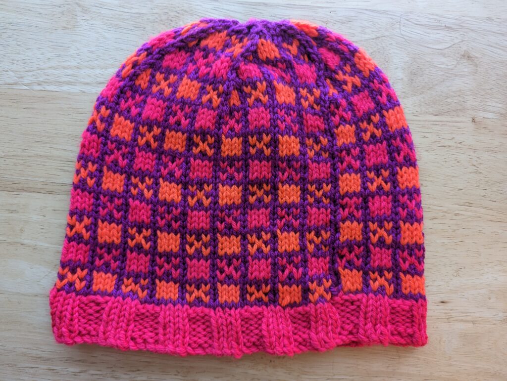 a pink brimmed and pink and orange alternating checkerboard block pattern with violet bordering